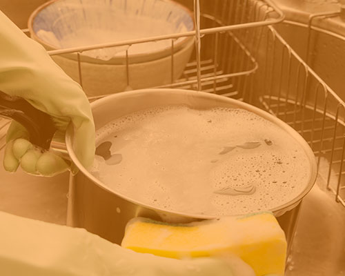 hand washing dishes in a sink