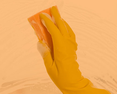 hand with dish glove on wiping with soapy sponge