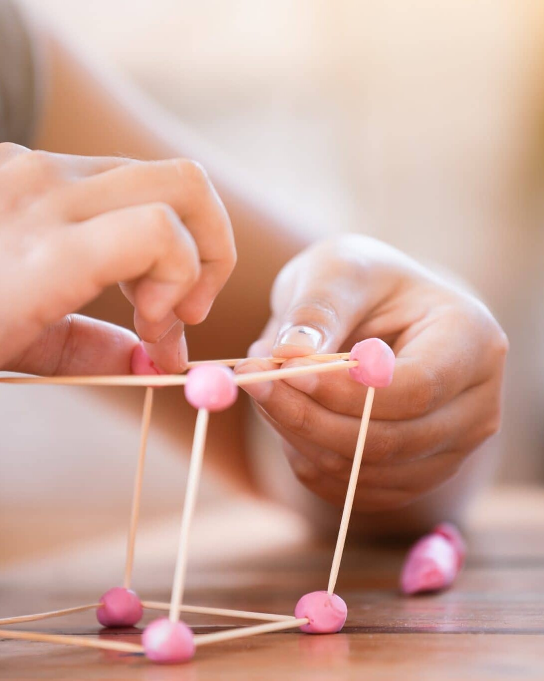 child's hands making a cube out of toothpicks and play doh
