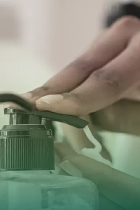 hand pushing soap dispenser